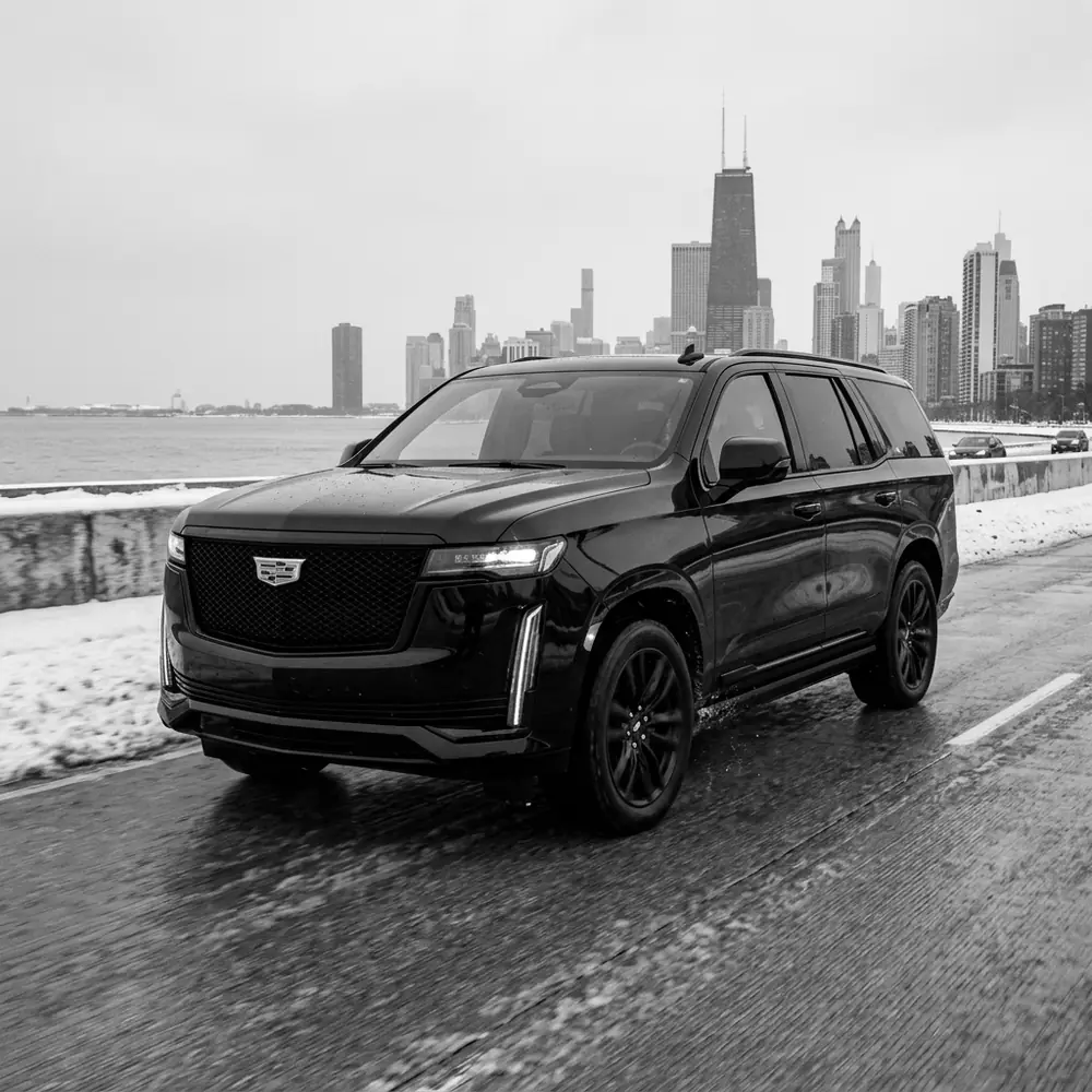 Black Cadillac Escalade on a snowy Chicago lakefront road in winter