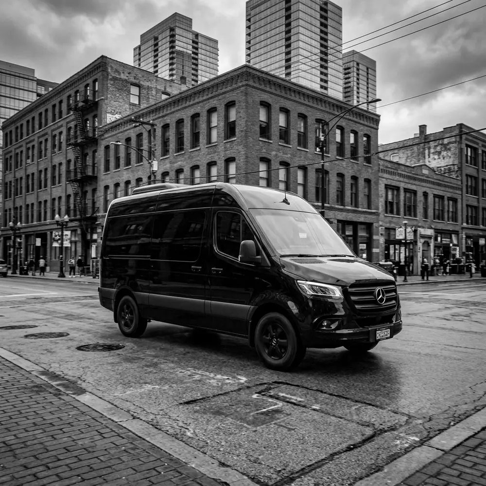 Black Mercedes-Benz Sprinter van on a brick street in the West Loop, Chicago